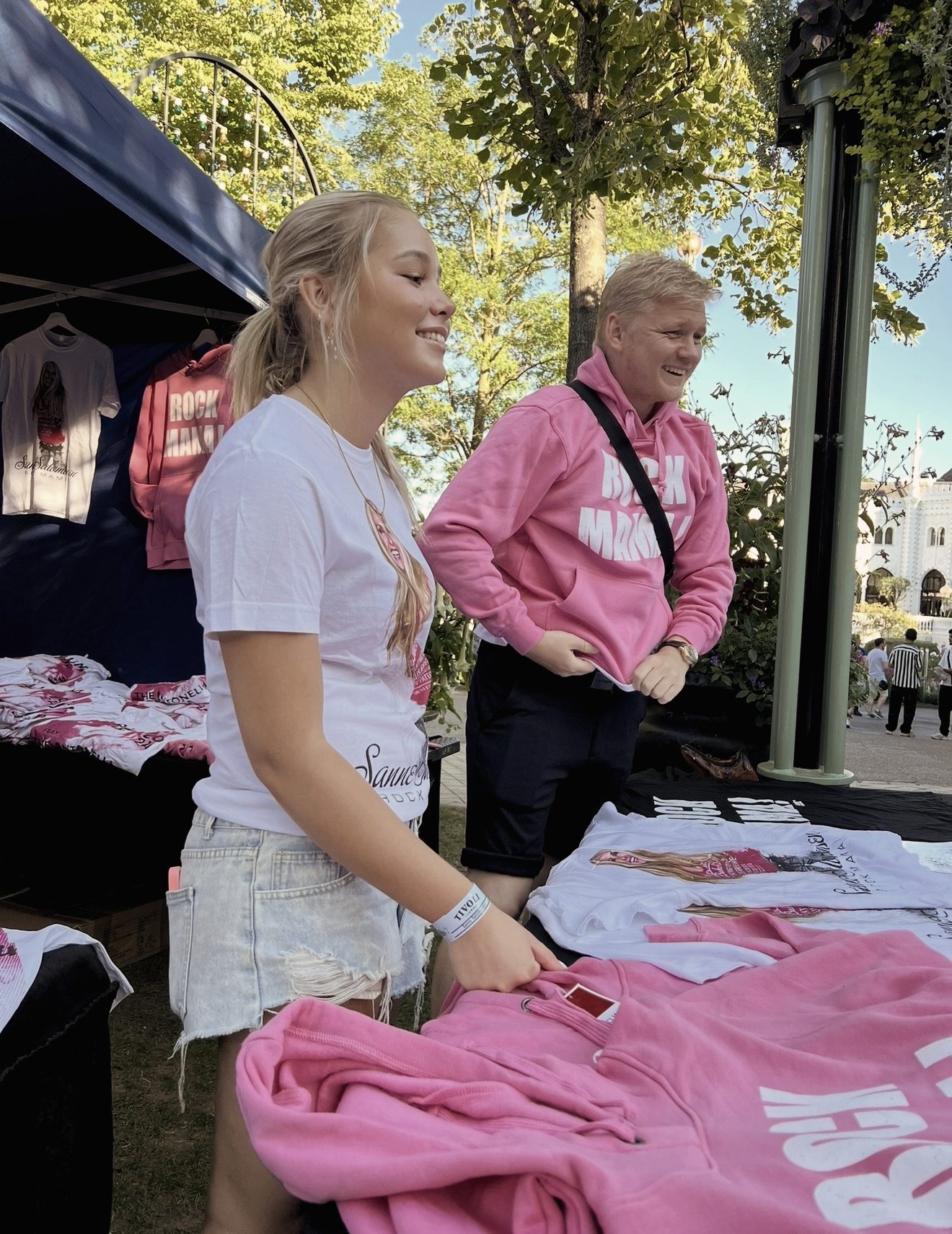 Merch-stand med pink hoodies og T-shirts ved en koncert
